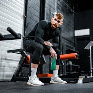 woman in black long sleeve shirt and black pants sitting on exercise equipment